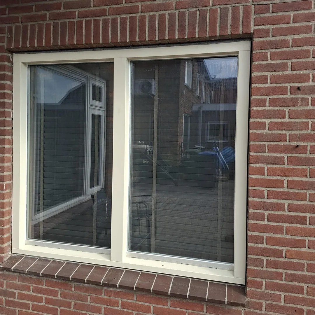 Nieuw kunststof kozijn met dubbele beglazing in een bakstenen gevel