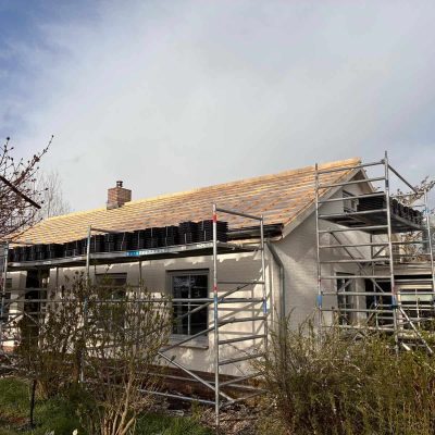 Nieuwe houten dakbeschieting aangebracht op de woning, met steigers eromheen