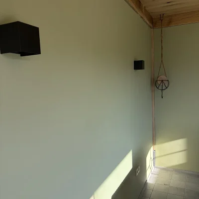 Zijaanzicht van de gevelbekleding en het houten kozijn van de tuinkamer