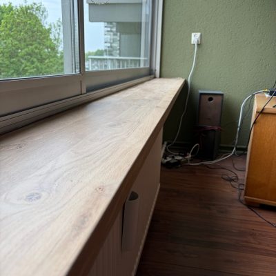 Nieuwe eiken vensterbank in de woonkamer, met uitzicht op groen en water